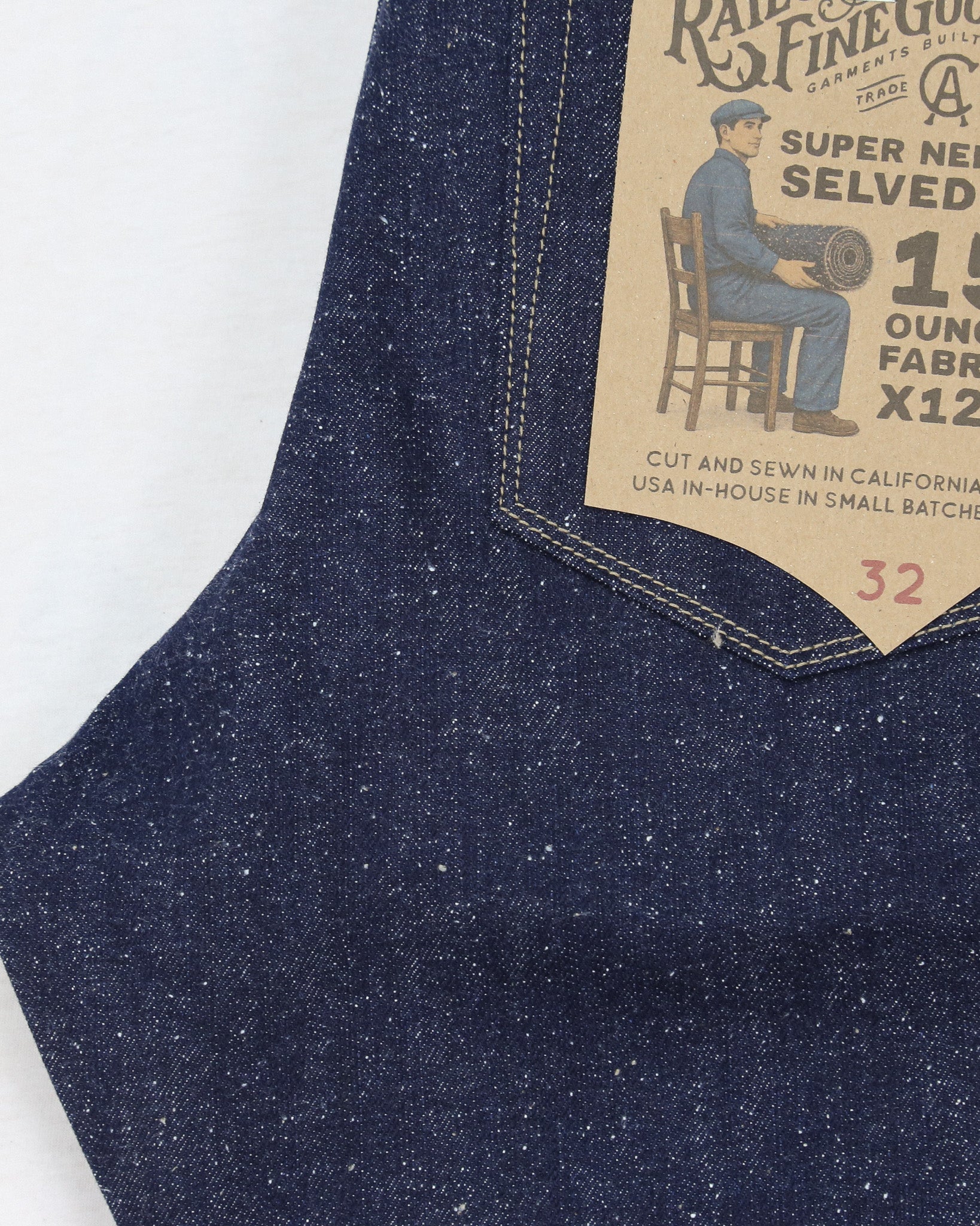 Close-up of blue denim fabric with a brand label on a white background